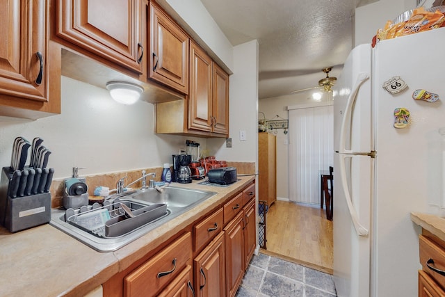 kitchen featuring white fridge, sink, and ceiling fan