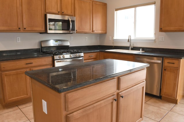 kitchen featuring sink, light tile patterned floors, stainless steel appliances, a kitchen island, and dark stone counters