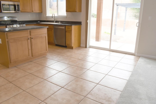 kitchen with sink, light tile patterned floors, and stainless steel appliances