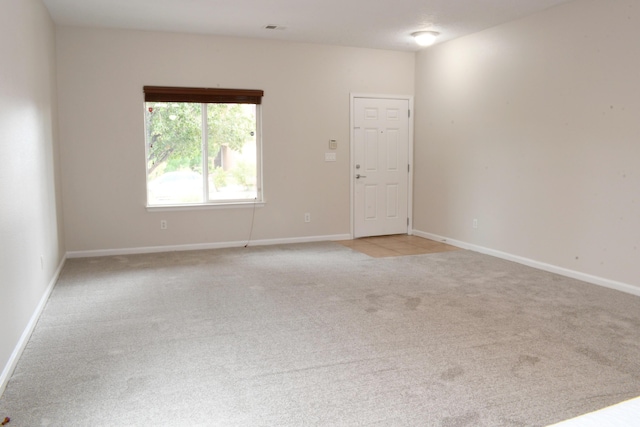 unfurnished room featuring light carpet