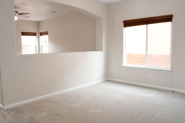 carpeted spare room featuring ceiling fan and a textured ceiling