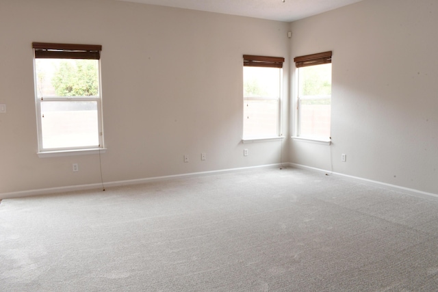 carpeted empty room with a healthy amount of sunlight