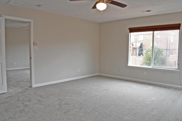 carpeted spare room featuring ceiling fan and a textured ceiling