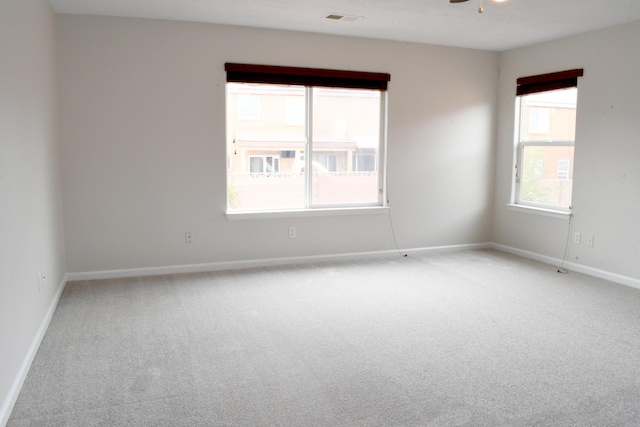 carpeted spare room featuring ceiling fan