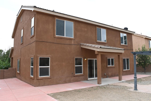 rear view of house featuring a pergola and a patio area