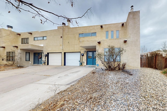 13428 Panorama Loop NE, Albuquerque, NM 87123 - pueblo-style home with driveway, stucco siding, and a chimney