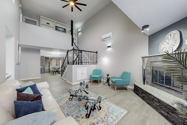 living room with light hardwood / wood-style flooring, high vaulted ceiling, and a wall mounted AC