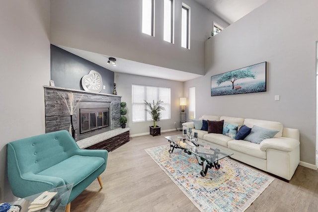 13428 Panorama Loop NE, Albuquerque, NM 87123 - living area with wood finished floors, a stone fireplace, baseboards, and a towering ceiling