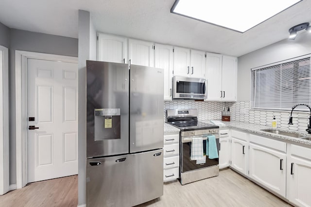 kitchen featuring stainless steel appliances, sink, and white cabinets