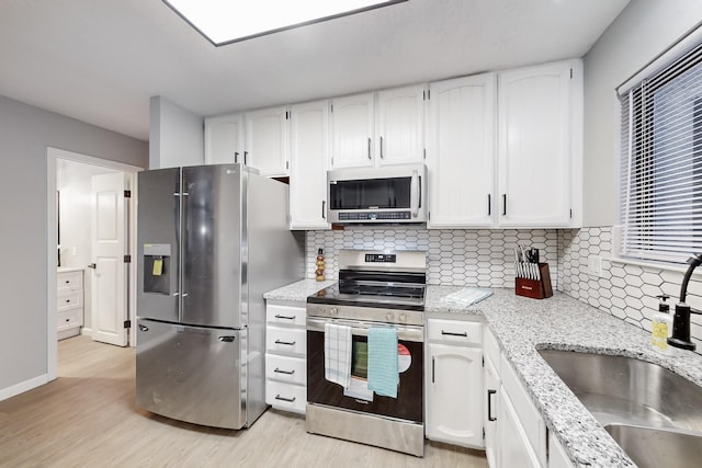 kitchen featuring sink, stainless steel appliances, light hardwood / wood-style floors, and white cabinets