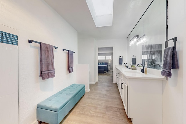 bathroom featuring vanity, wood-type flooring, and a skylight