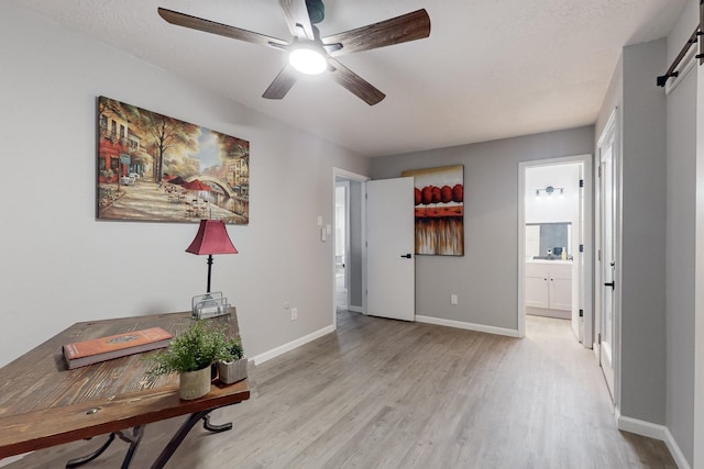 13428 Panorama Loop NE, Albuquerque, NM 87123 - interior space with a barn door, light wood-style floors, and baseboards