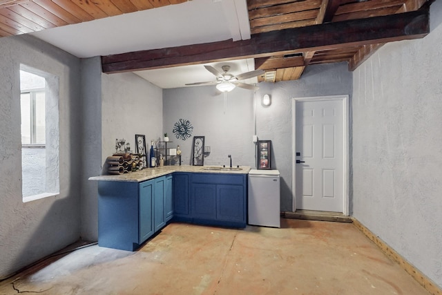 kitchen with blue cabinets, sink, fridge, beamed ceiling, and ceiling fan