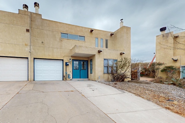 pueblo-style home featuring a garage