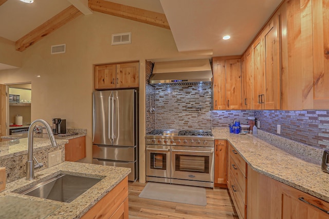 kitchen featuring appliances with stainless steel finishes, sink, light hardwood / wood-style floors, light stone countertops, and wall chimney exhaust hood