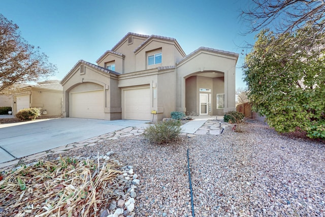 mediterranean / spanish-style home with concrete driveway, a tile roof, and stucco siding