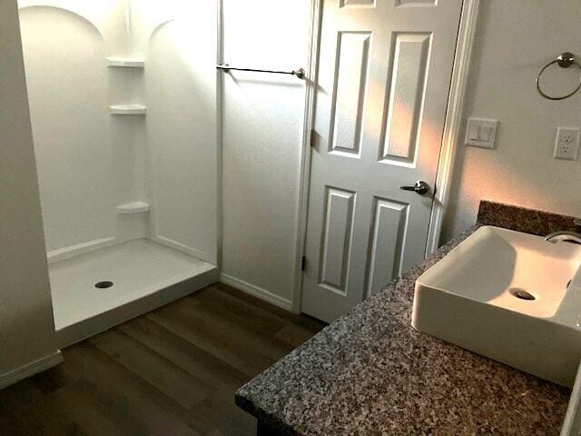 bathroom featuring a shower, wood-type flooring, and vanity