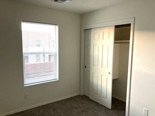 unfurnished bedroom with carpet floors and a closet