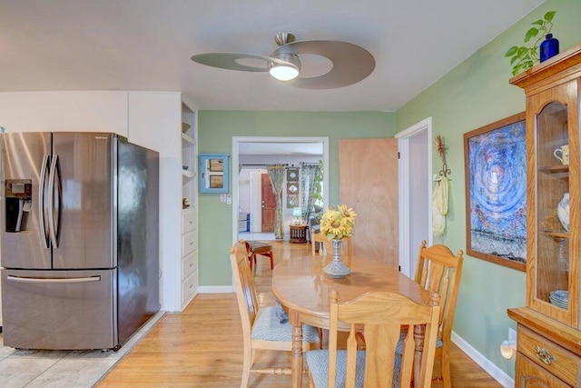 dining area with baseboards, light wood finished floors, and ceiling fan