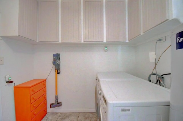 washroom featuring separate washer and dryer, cabinets, and light tile patterned flooring