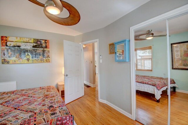 bedroom with hardwood / wood-style flooring, ceiling fan, and a closet