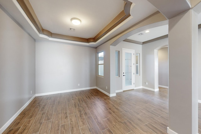 unfurnished room featuring wood-type flooring and a raised ceiling