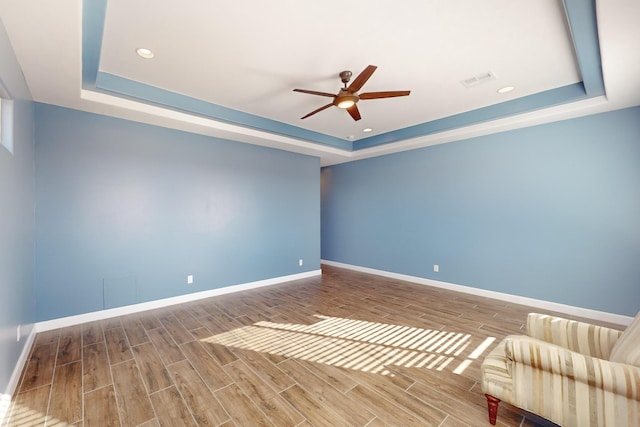 interior space with ceiling fan and a tray ceiling