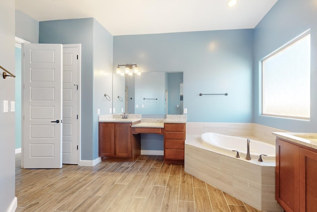 bathroom with vanity and tiled bath