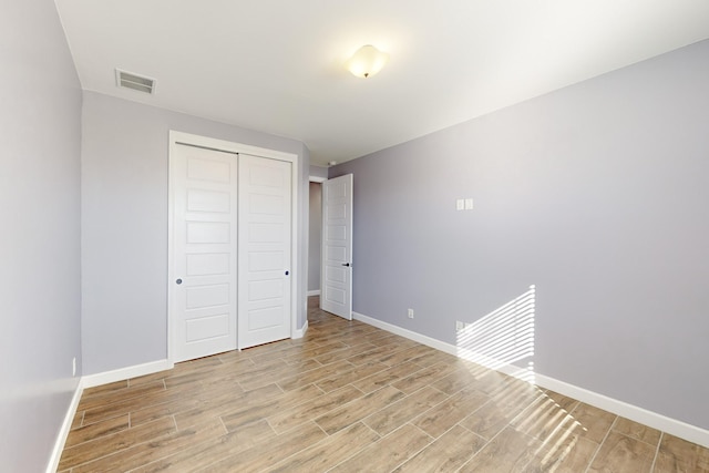 unfurnished bedroom featuring light wood-type flooring and a closet