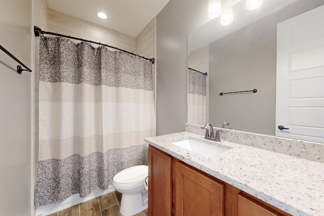 bathroom with vanity, toilet, and hardwood / wood-style floors