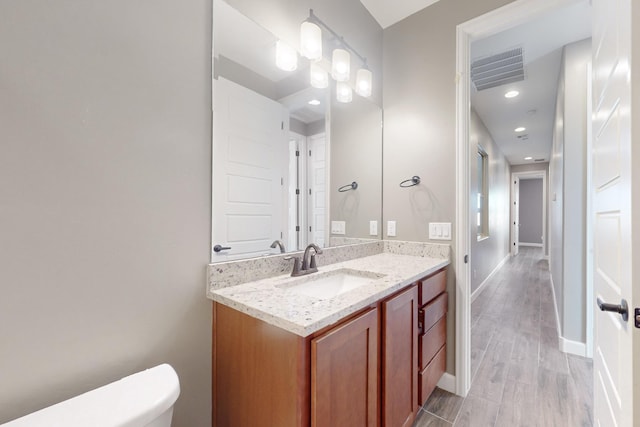 bathroom featuring vanity, toilet, and wood-type flooring