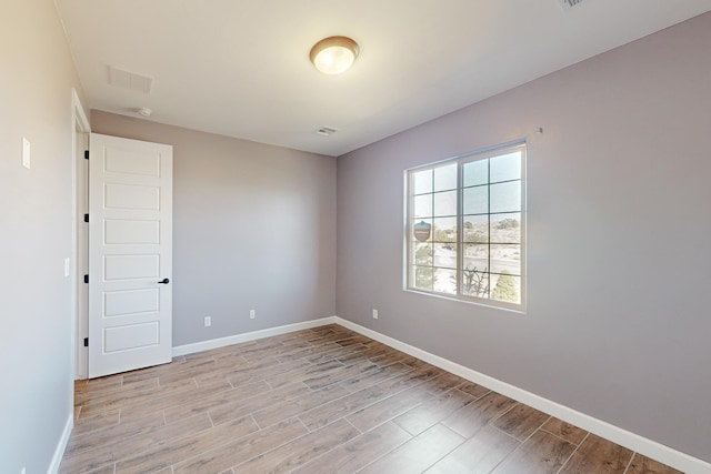 unfurnished room with light wood-type flooring