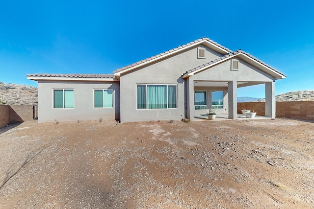 rear view of property featuring a patio and a mountain view