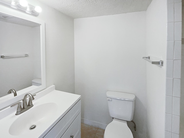 bathroom with vanity, tile patterned floors, a textured ceiling, and toilet