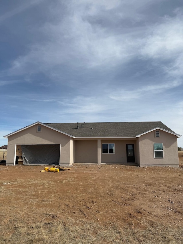 ranch-style home featuring a garage and stucco siding