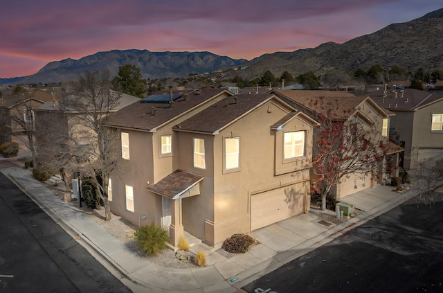 view of front of home with a mountain view and a garage