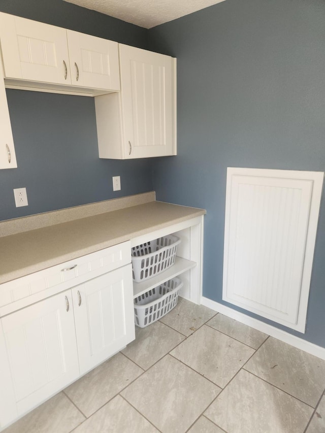 clothes washing area with light tile patterned floors