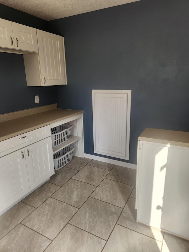 kitchen with white cabinetry and a textured ceiling