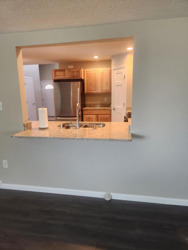 kitchen featuring dark hardwood / wood-style floors, stainless steel refrigerator, sink, and light brown cabinetry