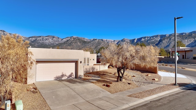 adobe home featuring a garage and a mountain view