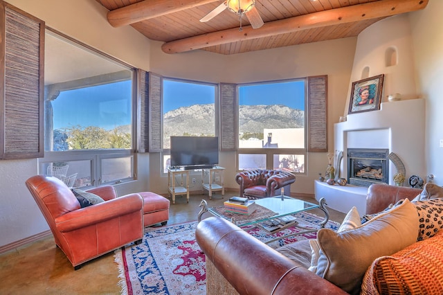 living room featuring ceiling fan, wooden ceiling, beam ceiling, and a wealth of natural light