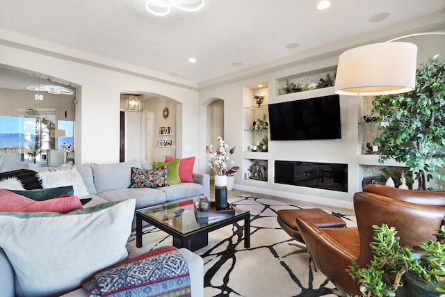 living room featuring built in features and a textured ceiling