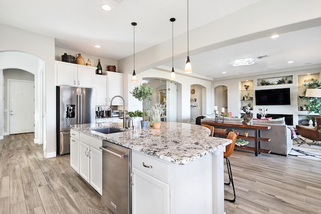 kitchen featuring a kitchen island with sink, sink, white cabinetry, and stainless steel appliances