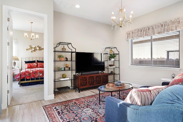 living room with a chandelier and light hardwood / wood-style floors