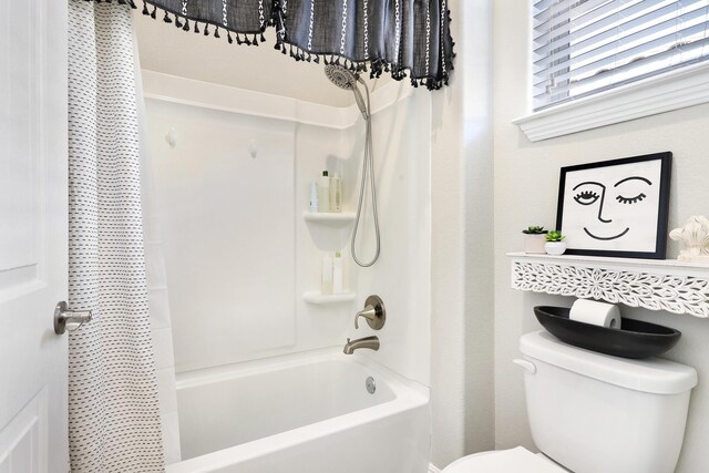 bathroom featuring shower / bath combination with curtain and toilet