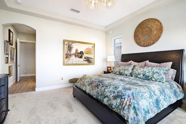 bedroom with an inviting chandelier and light colored carpet