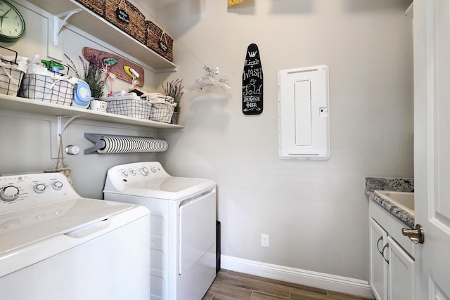 washroom with hardwood / wood-style flooring, cabinets, and washing machine and dryer