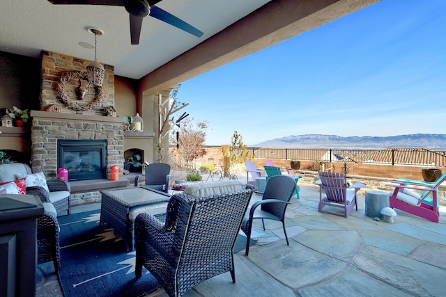 view of patio / terrace with a mountain view and an outdoor living space with a fireplace