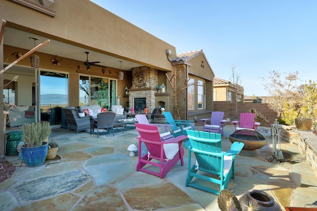 view of patio / terrace featuring an outdoor living space with a fireplace and ceiling fan