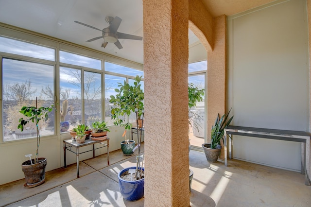 unfurnished sunroom featuring ceiling fan